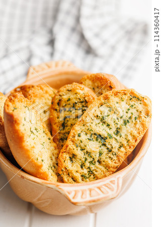 Garlic crisp bread Slices Topped With Herbs in bowl. Garlic crisp bread Slices Topped With Herbs in bowl. 114360417