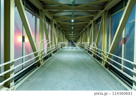 Symmetrical steel framework creates an industrial aesthetic, while the emptiness of the walkway Symmetrical steel framework creates an industrial aesthetic, while the emptiness of the walkway 114360681