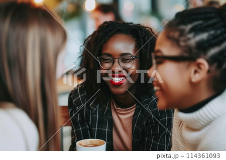 a cheerful group of friends sitting at a table talking in a cafe 114361093
