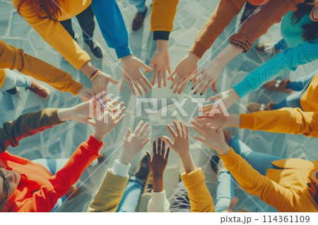 group of people standing in a circle raises their hands up 114361109