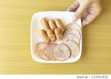 皿にのせたソーセージ類をもつ男性の手 皿にのせたソーセージ類をもつ男性の手 114361632