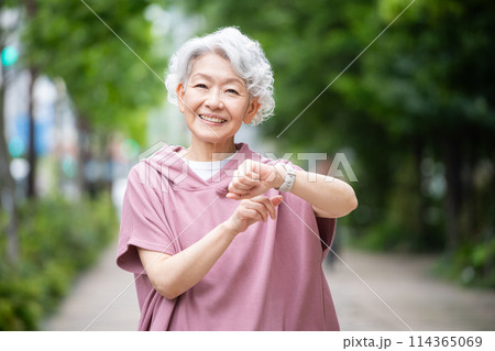 スマートウォッチを付けてウォーキングをする白髪のシニア女性 114365069