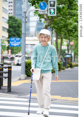 杖をついて街を散歩するシニア女性 杖をついて街を散歩するシニア女性 114365080