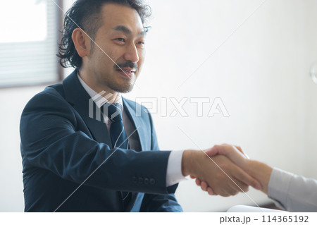 打ち合わせするスーツと作業着の男性 打ち合わせするスーツと作業着の男性 114365192