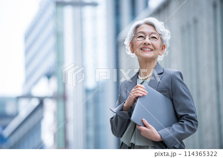 オフィス街でpcを持つシニア女性 114365322