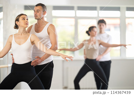 Ballet partners mastering paired technique at group class in studio 114367439