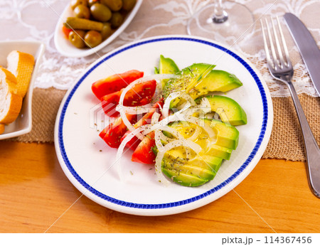 Salad from ripe avocado with tomatoes and onions 114367456