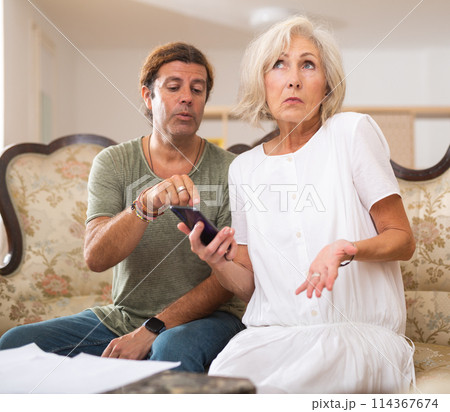 Man helping mature woman using her phone 114367674