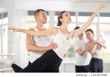 Graceful couple of ballet dancers performing supports at group class 114367686