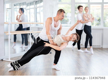 Ballet partners mastering paired technique at group class in studio 114367948