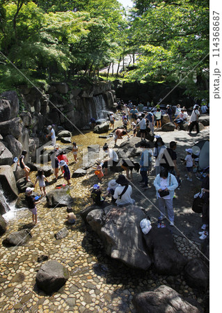 子供たちは水の流れるジャブジャブ池で楽しそうに遊ぶ。それを見ながら親も嬉しそう 子供たちは水の流れるジャブジャブ池で楽しそうに遊ぶ。それを見ながら親も嬉しそう 114368687