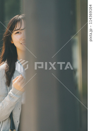 都会を歩く笑顔が可愛い20代女性 114369164
