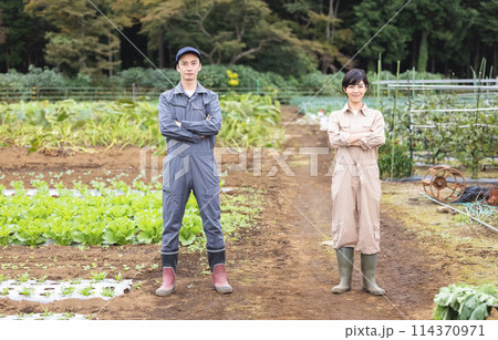 腕組みをする作業服の男女 腕組みをする作業服の男女 114370971
