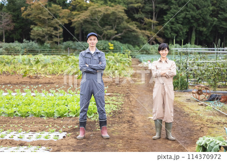 腕組みをする作業服の男女 腕組みをする作業服の男女 114370972