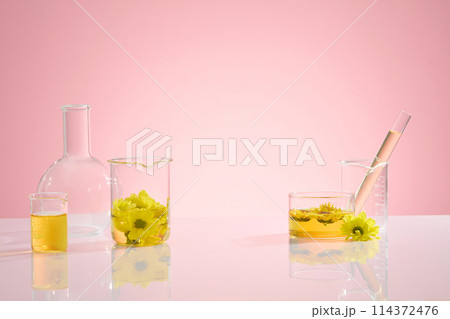 On the left side of table containing a boiling flask without anything inside, beaker of yellow essence, on the other side there are a few other utensils. Vacant for adding product or design elements 114372476