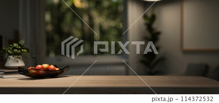 A copy space for displaying products on a wooden tabletop in a dark living room with a dim light. A copy space for displaying products on a wooden tabletop in a dark living room with a dim light. 114372532