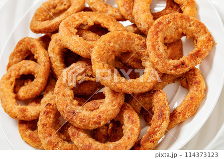 deep fried crispy onion rings on white plate 114373123