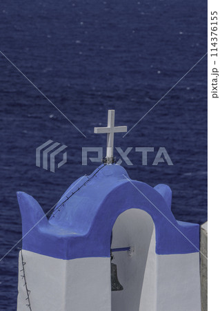 Greece, Santorini, Oia, Bell of a church with its white cross facing the sea 114376155