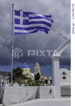 Greece, Santorini, Oia, Facade of the Orthodox church, Agios Giorgios, with a Greek flag Greece, Santorini, Oia, Facade of the Orthodox church, Agios Giorgios, with a Greek flag 114376230