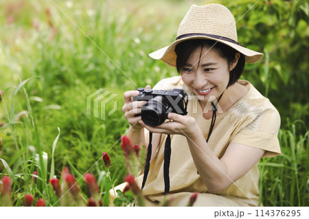 花畑でカメラを持つ女性 114376295