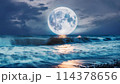 青く輝く満月と海に反射した海面に映る月 114378656
