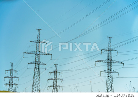 High voltage towers with sky background. Power line support with wires for electricity transmission. High voltage grid tower with wire cable at distribution station. Energy industry, energy saving 114378819