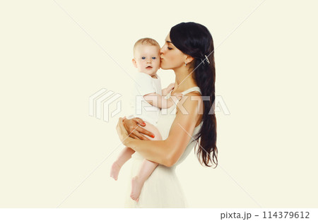 Happy young mother kissing baby on white studio background 114379612