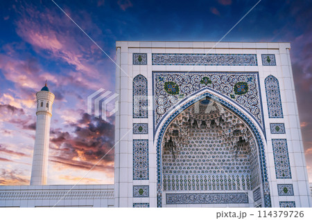 white marble wall decorated uzbek ornaments and minaret of modern Islamic Masjid Minor Mosque in Tashkent in Uzbekistan on background of sunset sky white marble wall decorated uzbek ornaments and minaret of modern Islamic Masjid Minor Mosque in Tashkent in Uzbekistan on background of sunset sky 114379726