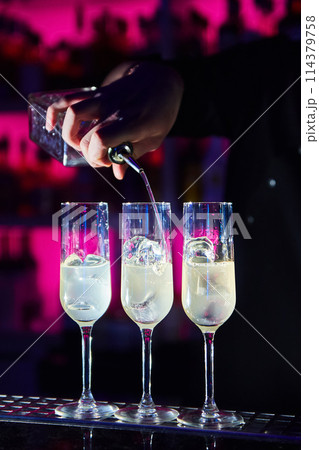 Bartender prepares alcoholic cocktail on bar counter 114379758