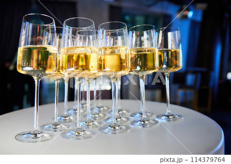 Set of glasses with white wine on a buffet table Set of glasses with white wine on a buffet table 114379764