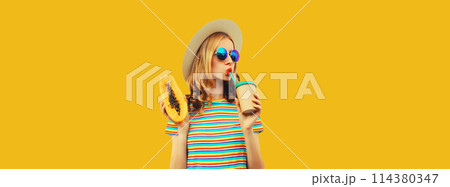 Summer portrait of stylish young woman with papaya fruit drinking fresh juice on yellow background 114380347