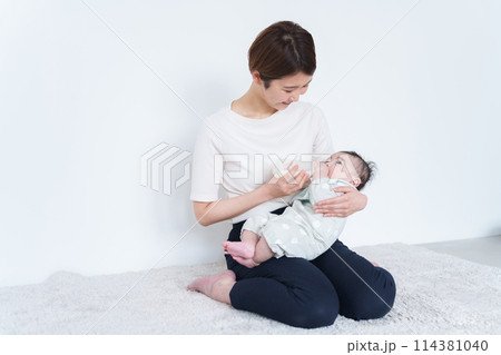 赤ちゃんにミルクをあげるママ 114381040