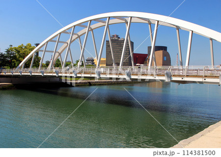 青空下の小倉リバーウォークと紫川に掛かる橋 114381500