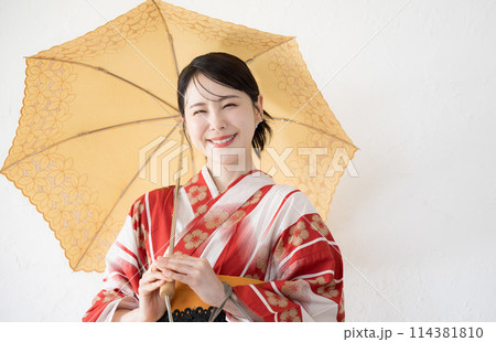 日傘をさす浴衣のかわいい日本人女性　夏の日差しを乗り切る日本の和服のカメラ目線 114381810