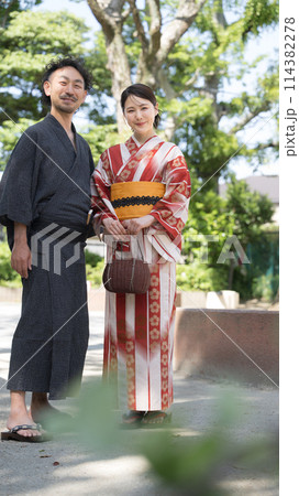 夏の緑の屋外で浴衣でデートをする大人のカップル　全身　カメラ目線の全身 114382278