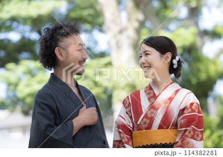 夏の緑の屋外で浴衣でデートをする大人の日本人カップル　見つめ合って会話する 114382281