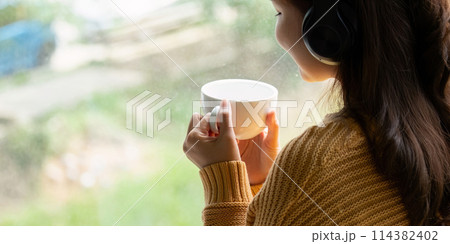 Beautiful young asian woman enjoy drinking coffee and listening to music with headphone at desk home, happiness and relaxation concepts Beautiful young asian woman enjoy drinking coffee and listening to music with headphone at desk home, happiness and relaxation concepts 114382402
