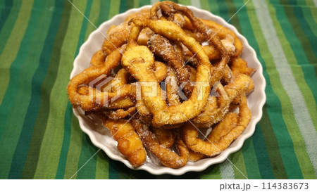 A tray of fried dough snakes with sugar ready to eat. Italian tradition. A tray of fried dough snakes with sugar ready to eat. Italian tradition. 114383673
