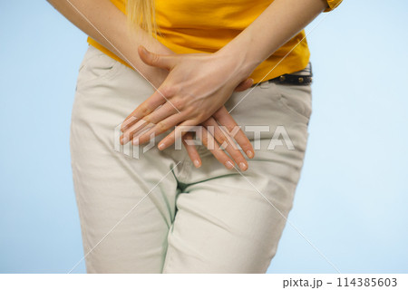 Woman with hands holding her crotch Woman with hands holding her crotch 114385603