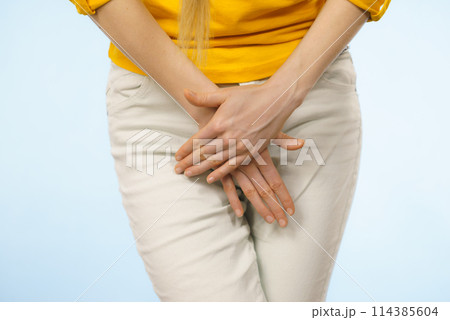 Woman with hands holding her crotch 114385604