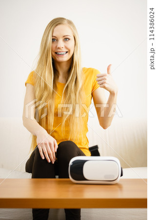 Happy young woman next to VR Happy young woman next to VR 114386024
