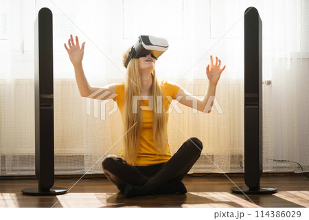 Girl wearing virtual reality goggles at home Girl wearing virtual reality goggles at home 114386029