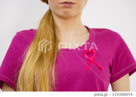 Woman having pink breast cancer ribbon on tshirt 114386054
