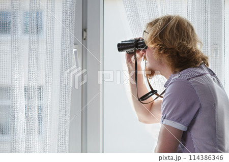Man with binoculars spying on neighbors Man with binoculars spying on neighbors 114386346