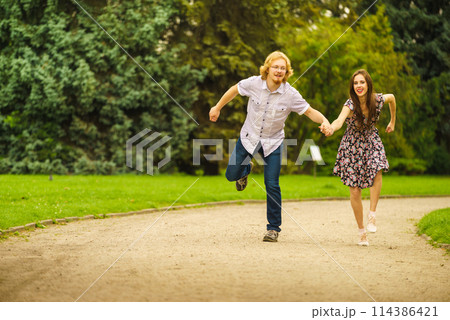 Happy couple playing in park Happy couple playing in park 114386421