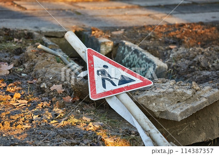Construction site sign over a utility hole Construction site sign over a utility hole 114387357