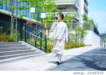 ショッピングバッグを持って街を歩く女性 114387514