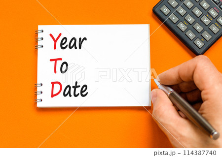 YTD year to date symbol. Concept words YTD year to date on beautiful white note. Beautiful orange background. Businessman hand. Business YTD year to date concept. Copy space. YTD year to date symbol. Concept words YTD year to date on beautiful white note. Beautiful orange background. Businessman hand. Business YTD year to date concept. Copy space. 114387740