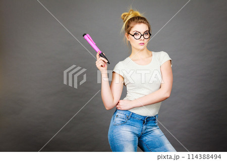 Woman holding big oversized pencil thinking about something 114388494