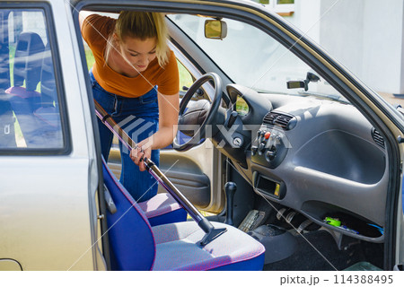 Cleaning car interior with vacuum cleaner 114388495